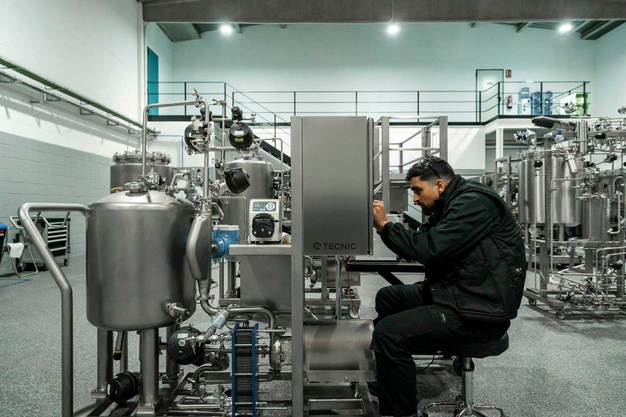 Ingeniero realizando mantenimiento a equipo de proceso de acero inoxidable en planta